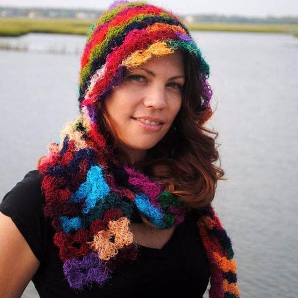 woman smiling in a lake wearing a colorful hood