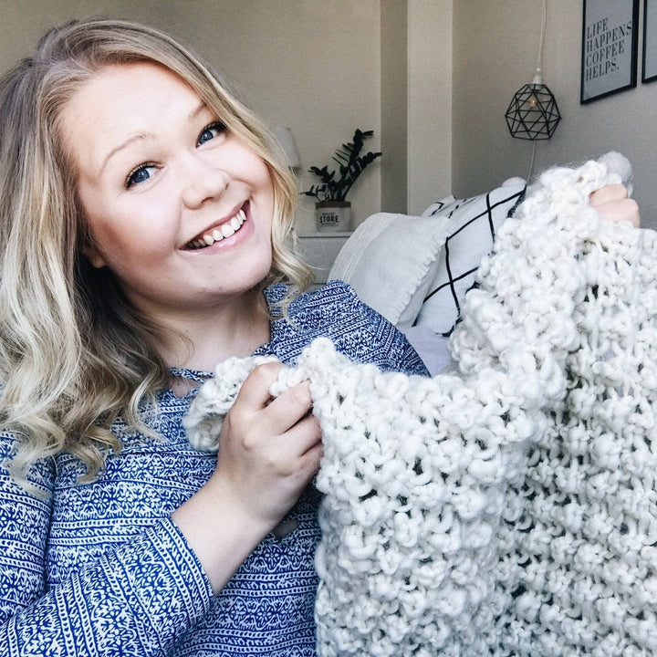 woman smiling and holding a white blanket