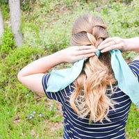 girl holding her hair with sari silk fabric and trees in the background