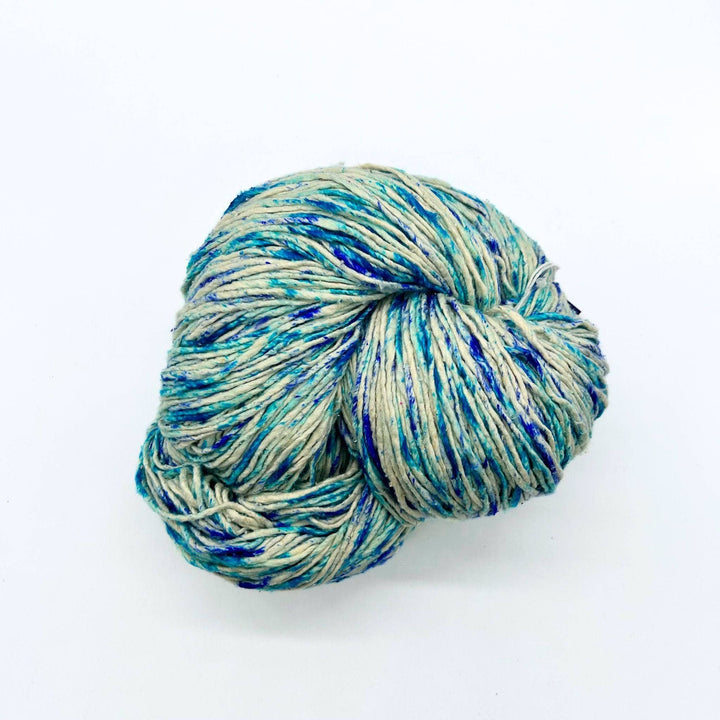A skein of light blue and beige speckled yarn