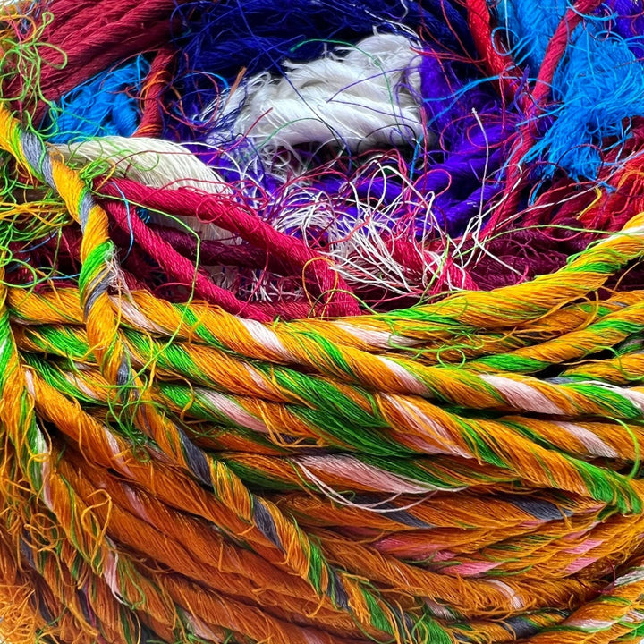 An upclose shot of 'Spice Market' Reclaimed Sari Silk Yarn. Showing the textures of the yarn.
