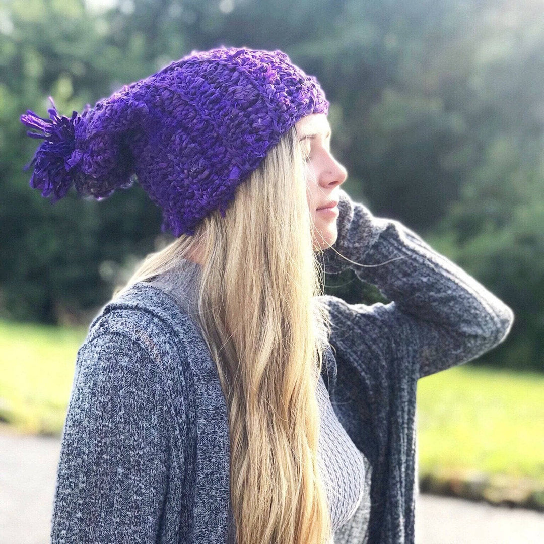 Side view of a girl wearing a purple sari ribbon hat outside