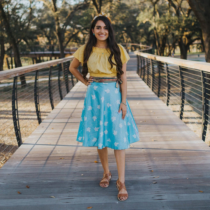 A woman standing on a wooden bridge.
