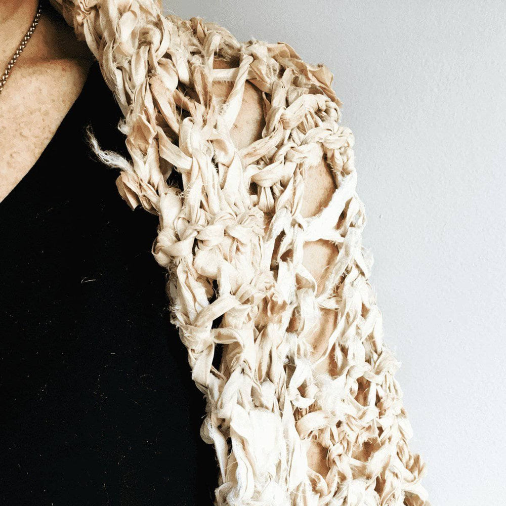 A close up of a woman shoulder wearing silk garter lace summer cocoon coat.