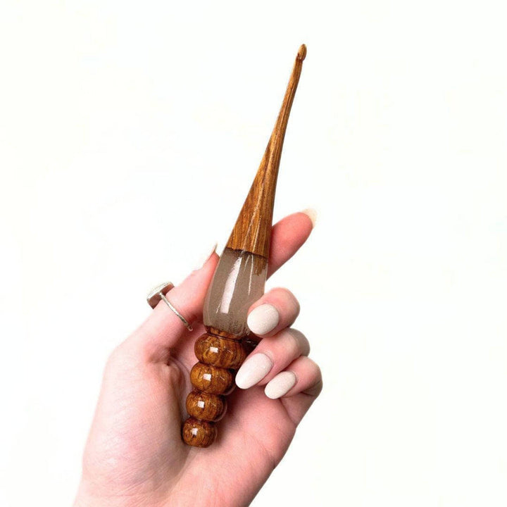 Two wooden and resin crochet hooks.