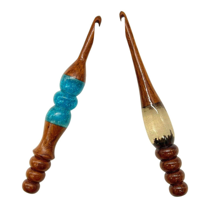 Two wooden and resin crochet hooks.