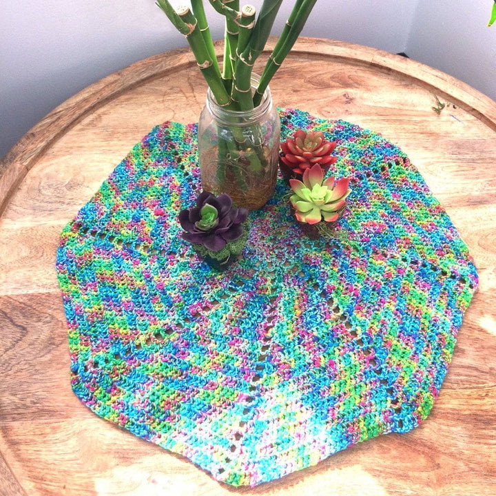 Spiral Fan Doily in Crocodile Snap (turquoise) on a wooden surface