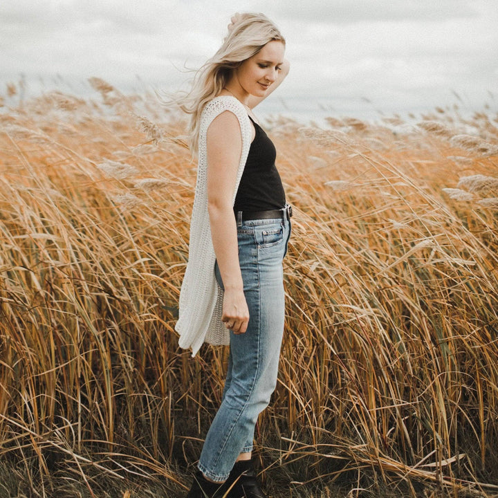 A women wearing a white vest in a hay field