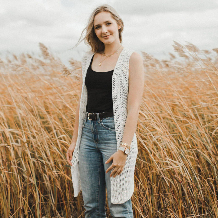 A women wearing a white vest in a hay field
