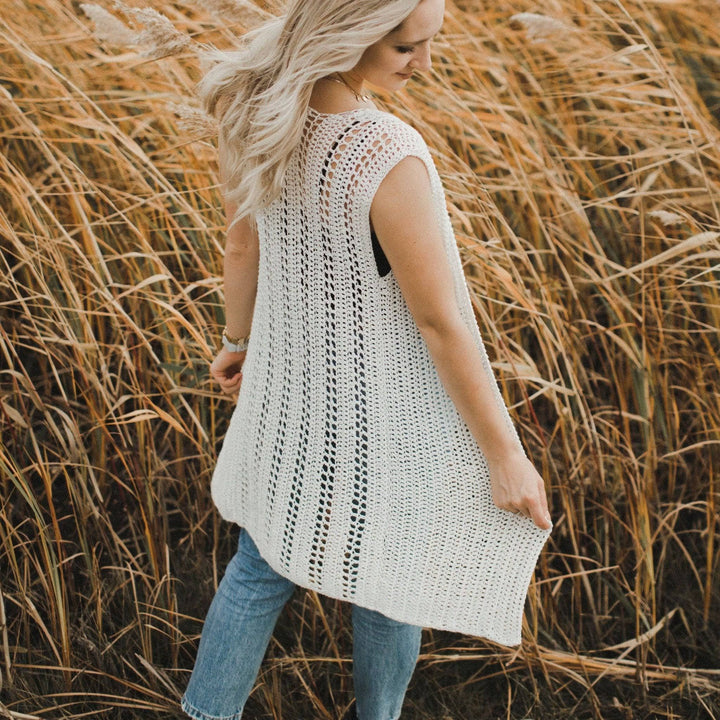 A women wearing a white vest in a hay field