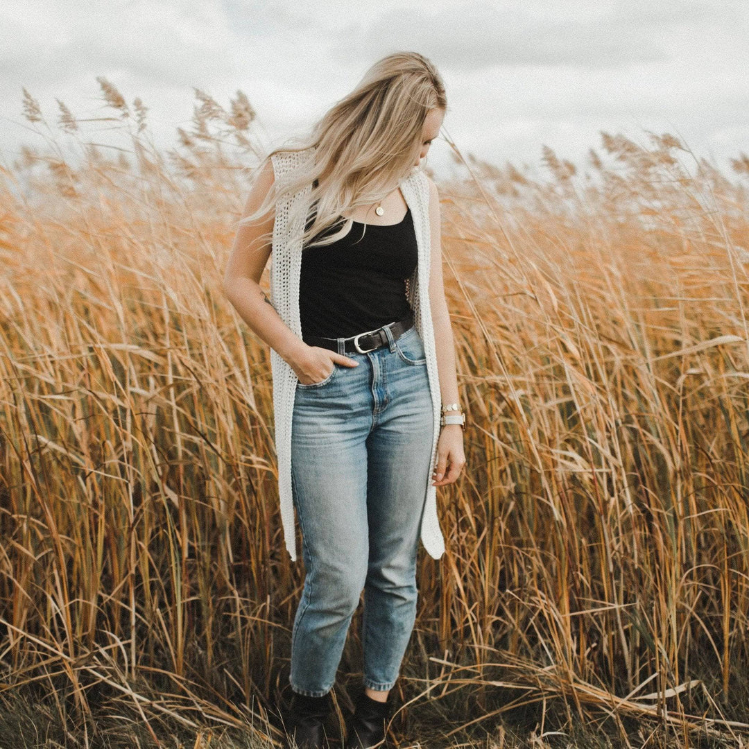 A women wearing a white vest in a hay field