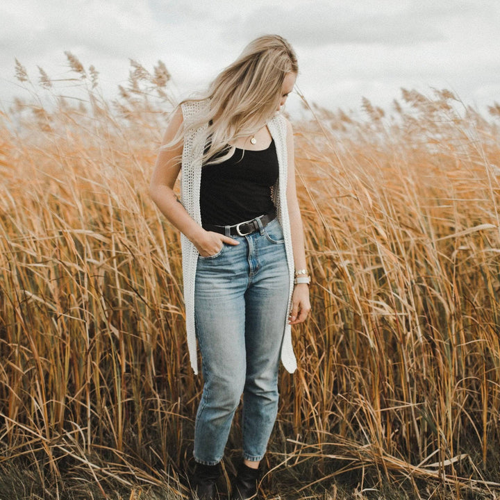 A women wearing a white vest in a hay field
