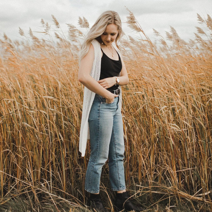 A women wearing a white vest in a hay field