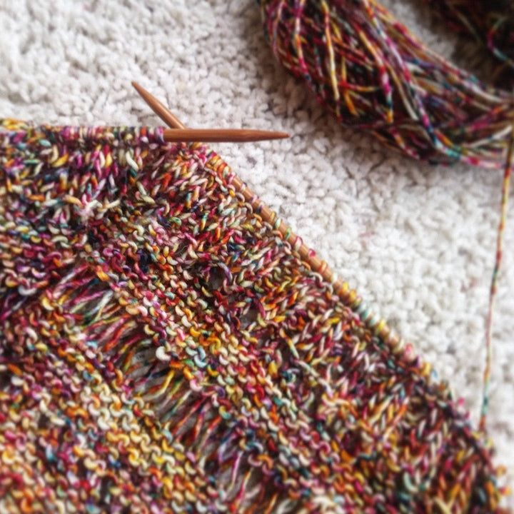 In progress picture of a yellow and red speckled shawl 