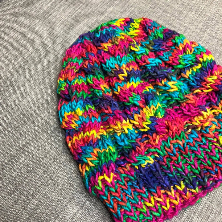 completed magnolia beanie in watercolors in front of a textured grey background. 