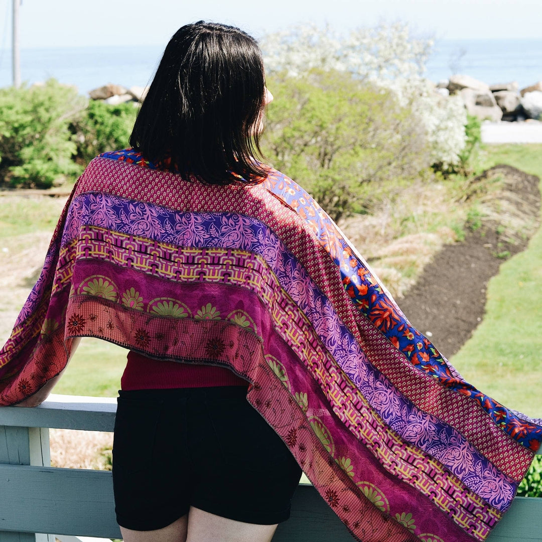 pink Medley scarf sitting on the back of models shoulders while they look into the distance. 