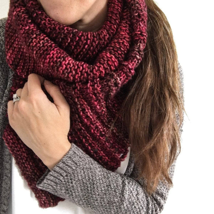 Woman wearing the Milan Scarf in Jupiter (red) against a white wall