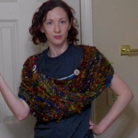 Woman wearing Wild Peacock Wrap in multicolored against a white door