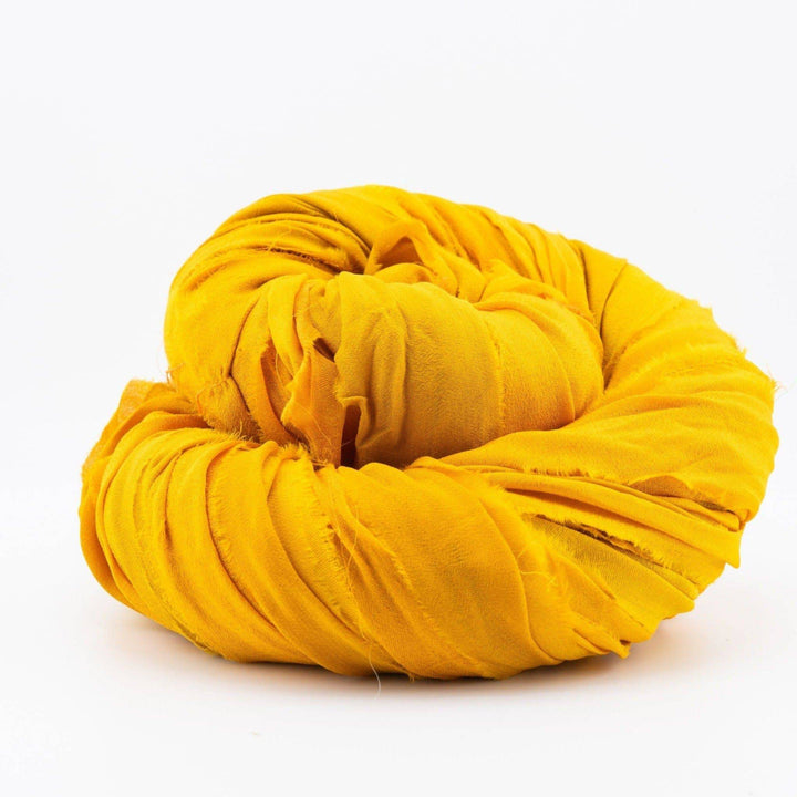 A coiled bundle of bright yellow fabric against a plain white background.