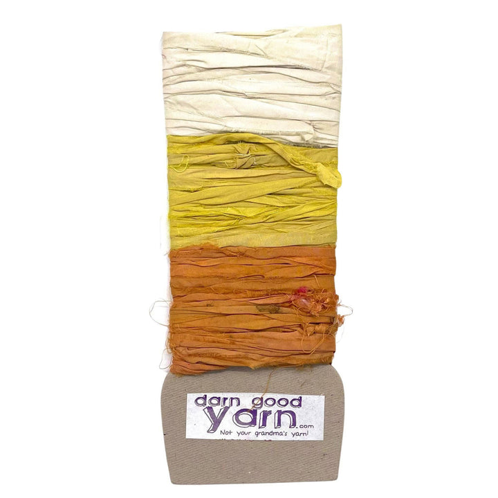 A package of silk yarn in warm gradient colors, from white to orange, by "Darn Good Yarn."