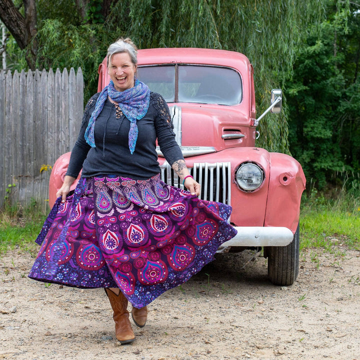 Model wearing purple cotton wrap skirt in front of an old car.