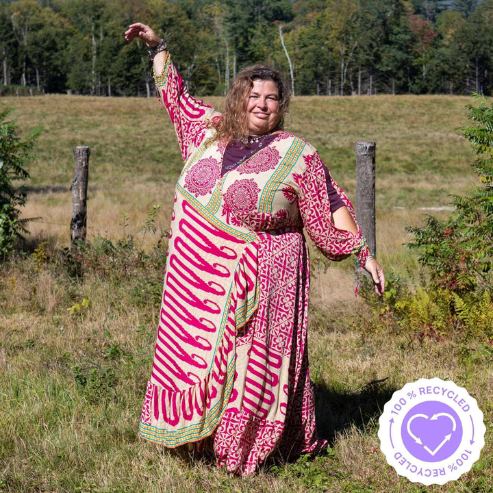 A woman on a farm wearing a warm tone Zaria Wrap Dress in Warm tones.