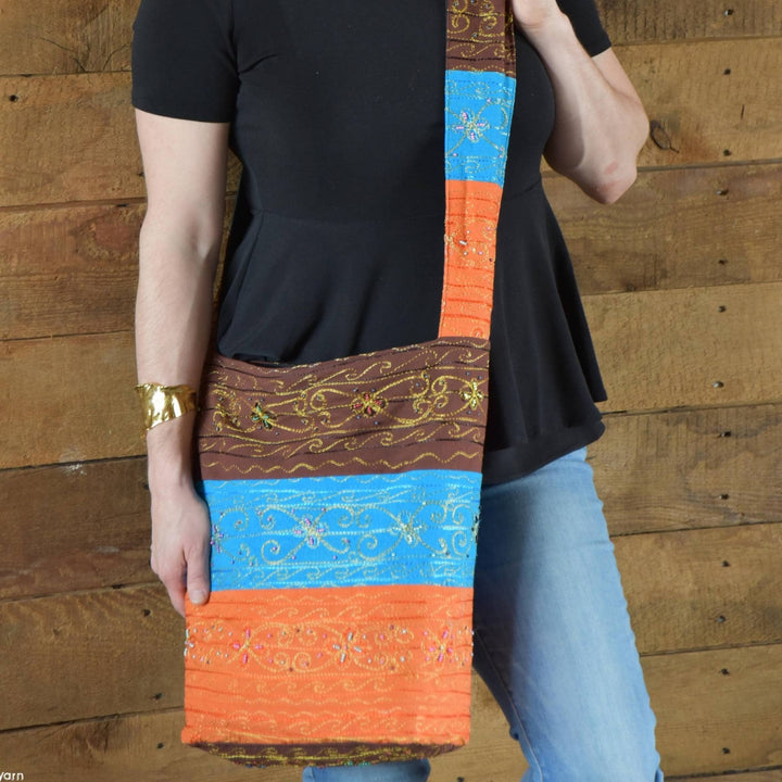 Close up view of model wearing Earth Wind Fire Boho Sling Crossbody Bag. 