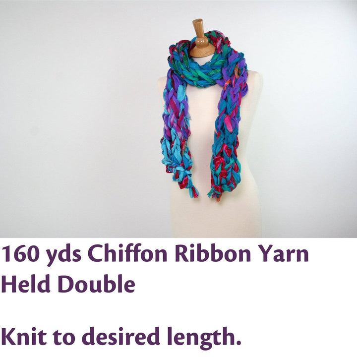 Yarn requirement and specs image. Mannequin with 30 minute arm knit scarf in blue red and purple. Text reads: 160 yds Chiffon Ribbon Yarn Held Double, and knit to desired length.