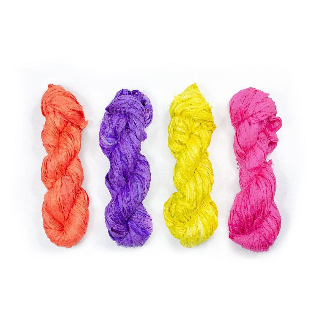 four multicolored yarn skeins over a white background