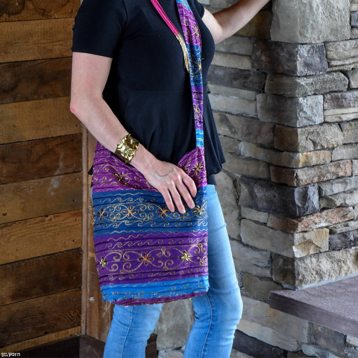Model wearing Boho Night Life Sling Crossbody Bag in front of a cement fire place. 
