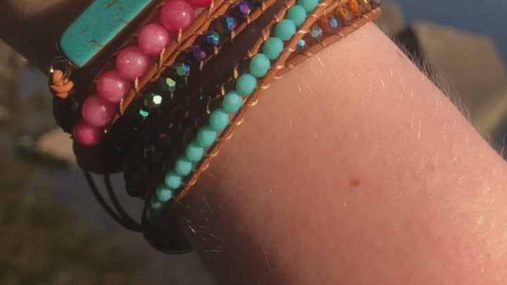 Video of Turquoise and Pink Beaded Wrap Bracelet on the model's wrist in front of a body of water. 