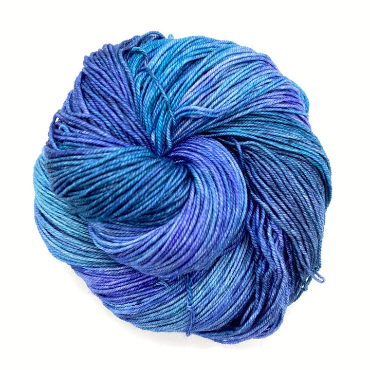skein of tonal blue yarn in front of a white background
