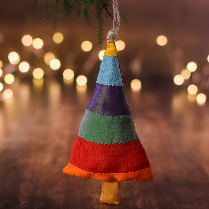 Christmas tree shaped ornaments handing with Christmas light in the background