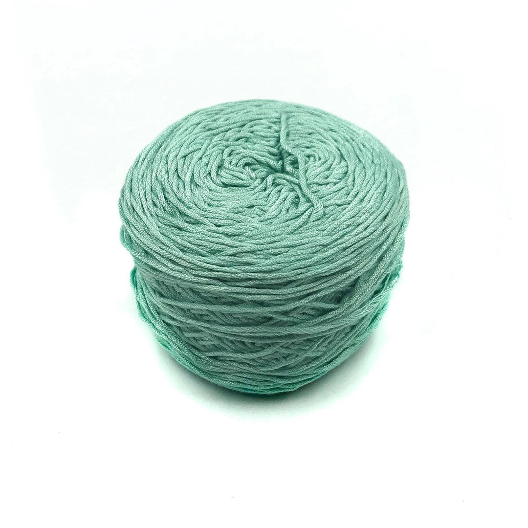 Viscose & Cotton Baby Yarn cake in Baby Cosmos (green) on a white background
