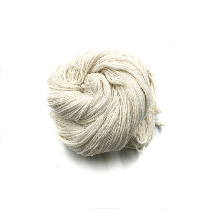 close up of yarn in the color natural (white) with a white background