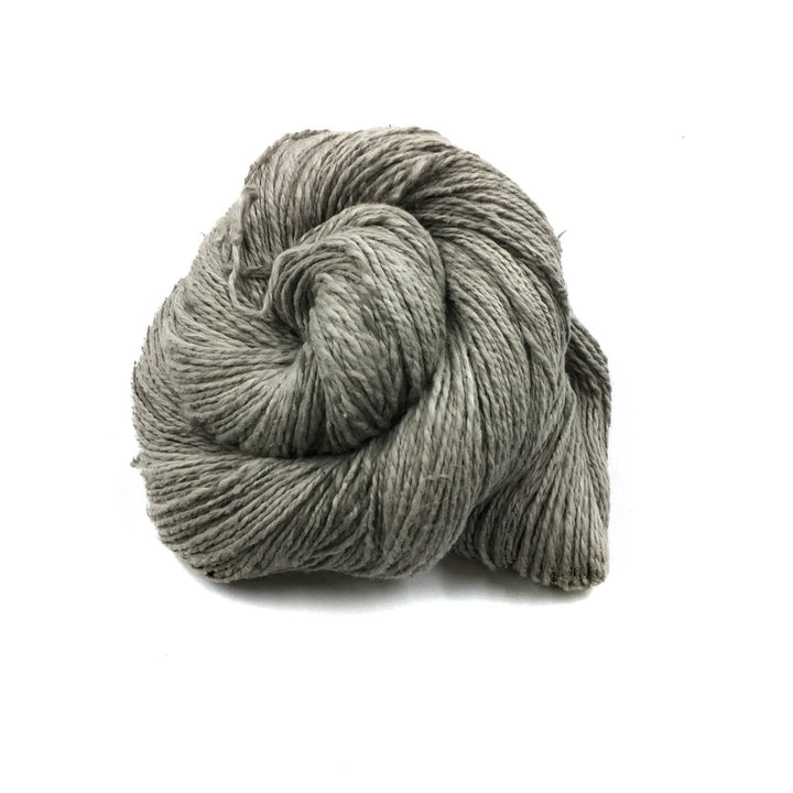 close up of yarn in the color salvi (grey) with a white background
