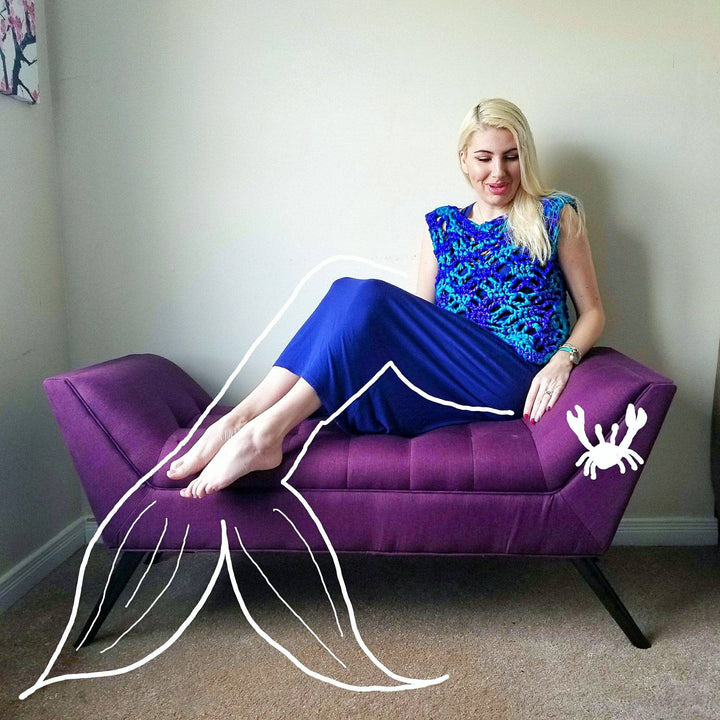 woman sitting in a purple sofa with a colorful summer crochet top