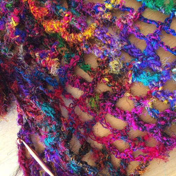 close up of the strings of a rainbow shawl