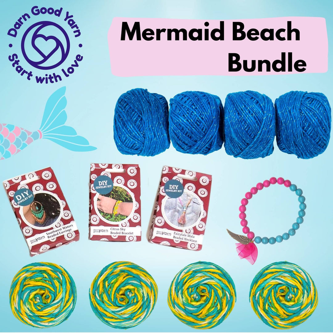 mermaid beach bundle with all items showing in front of a light blue background. 4 skeins silk roving worsted weight ocean light 4 skeins silk roving worsted weight classic blue, 3 diy jewelry making kits, one completed bracelet.