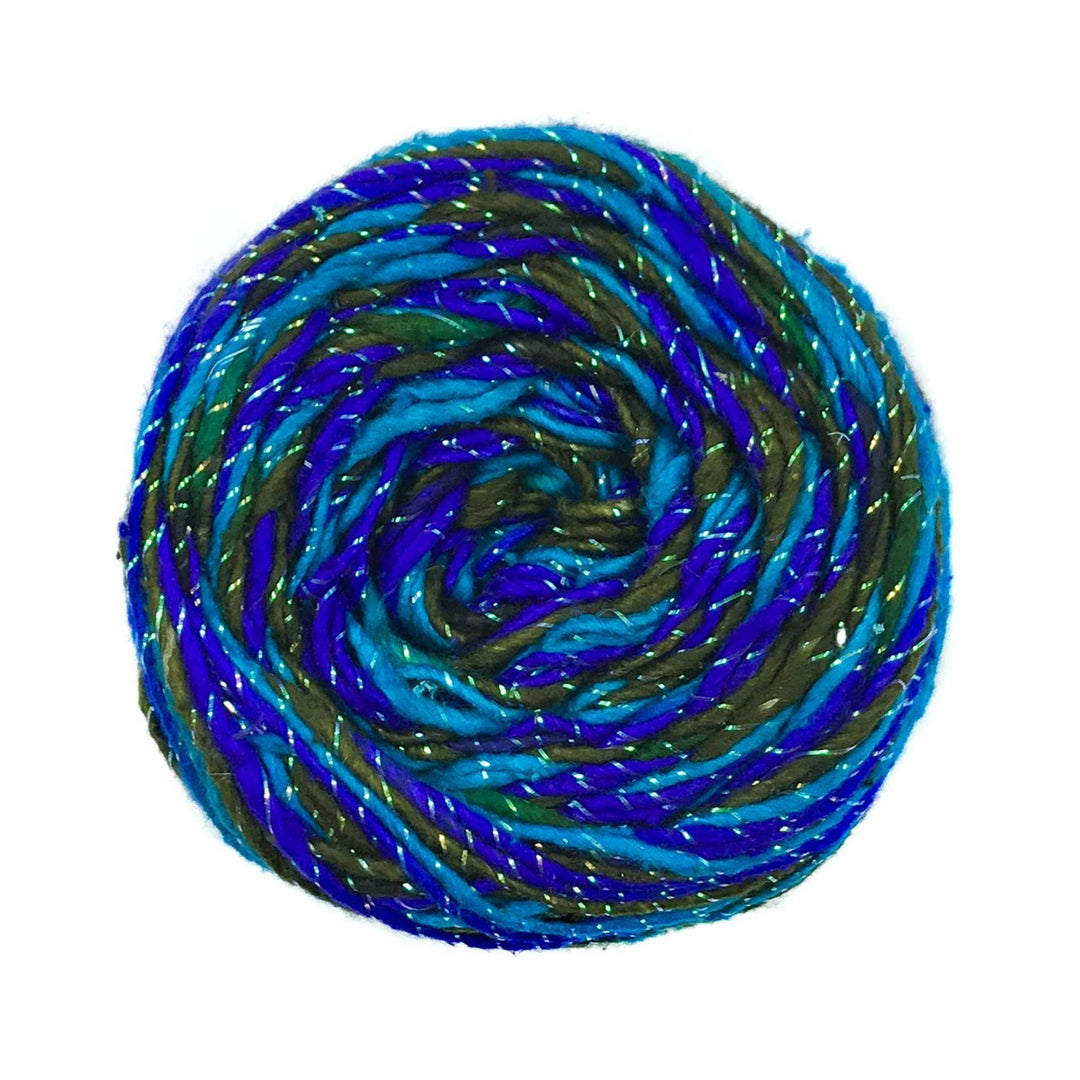 light blue, dark blue, forest green variegated sparkle yarn in front of a white background.