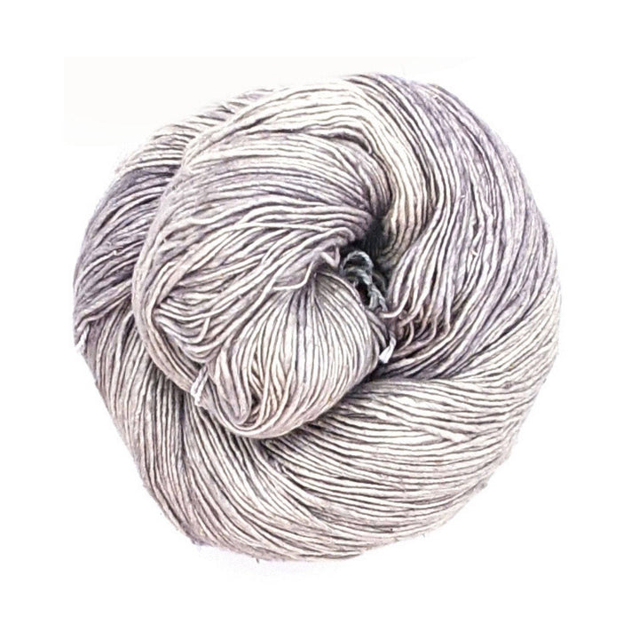 Single skein of lace weight silk yarn in the colorway ultimate grey in front of a white background.