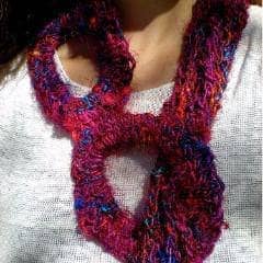 Close up of woman wearing Roundabout Way Scarf in a deep pink color and a white t shirt