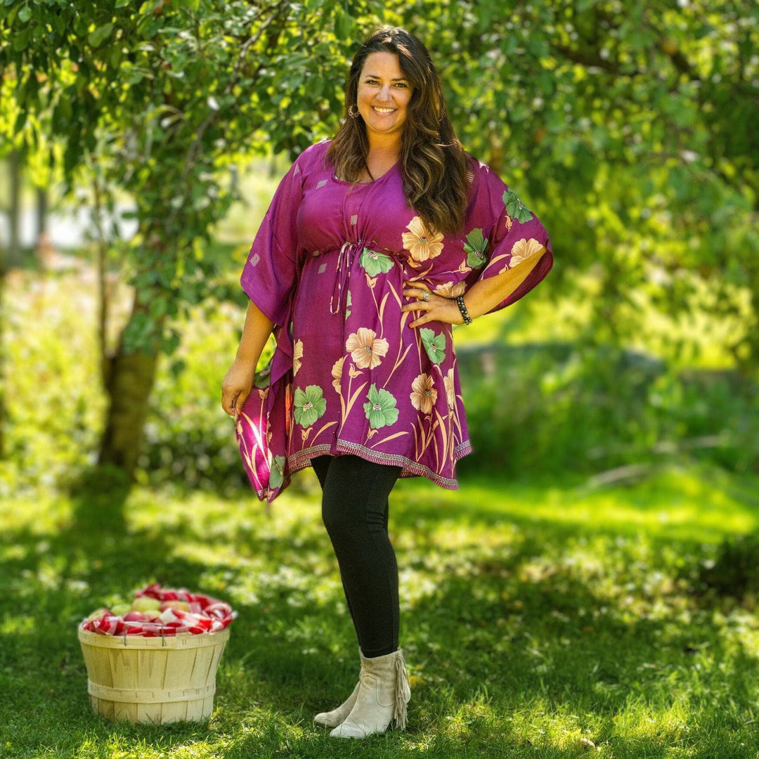 Woman standing next to a basket of apples wearing aanya short kaftan