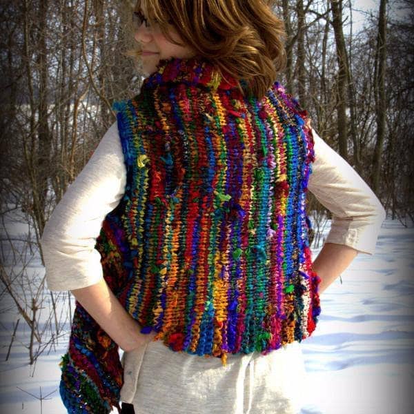 Woman wearing Adventure Cardi vest in multicolor standing in front of a snowy landscape
