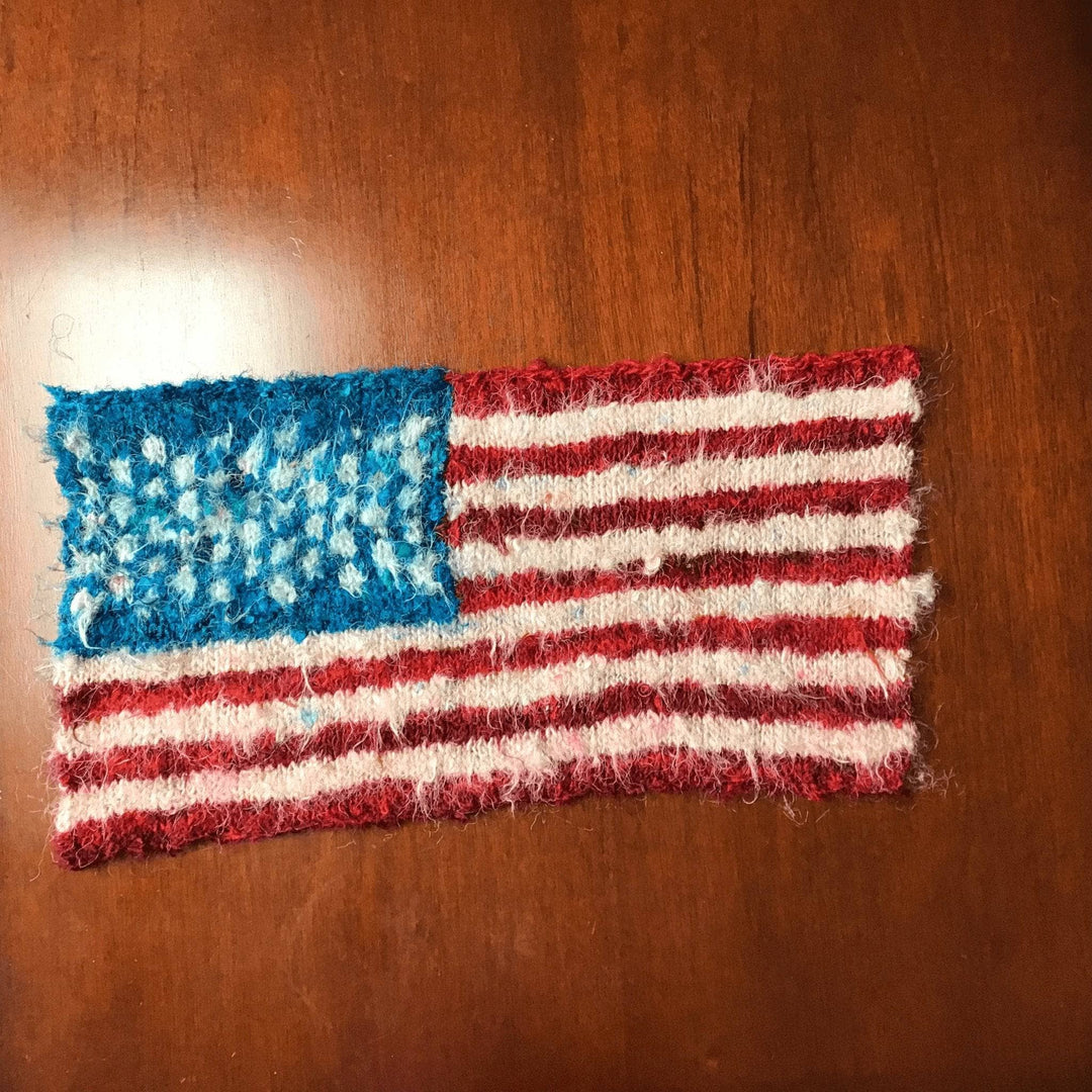 Knit American Flag laid on a wooden surface