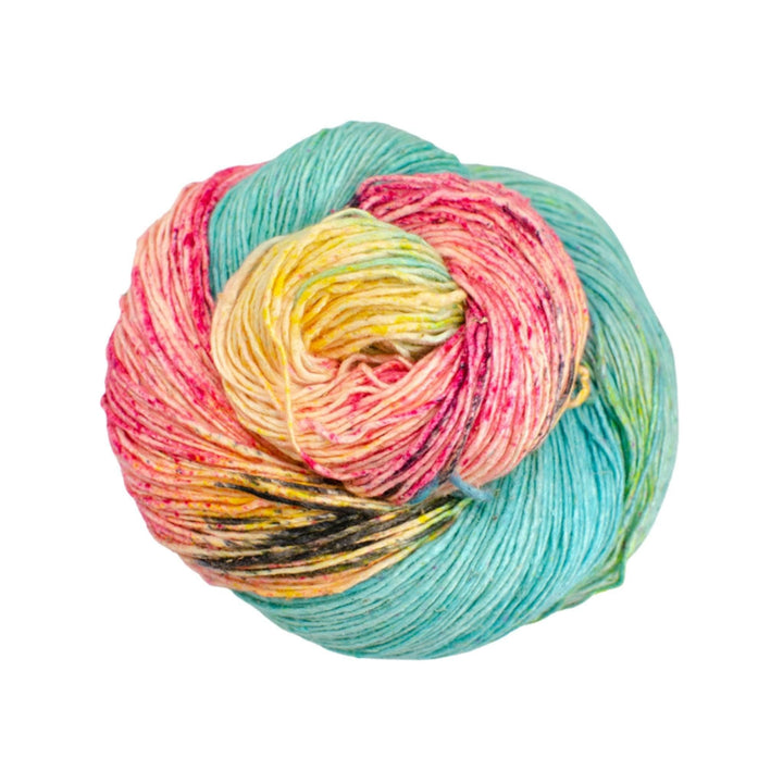 skein of lace weight silk yarn in the colorway pastel dreams in front of a white background. Blue, pink, yellow with black speckles/