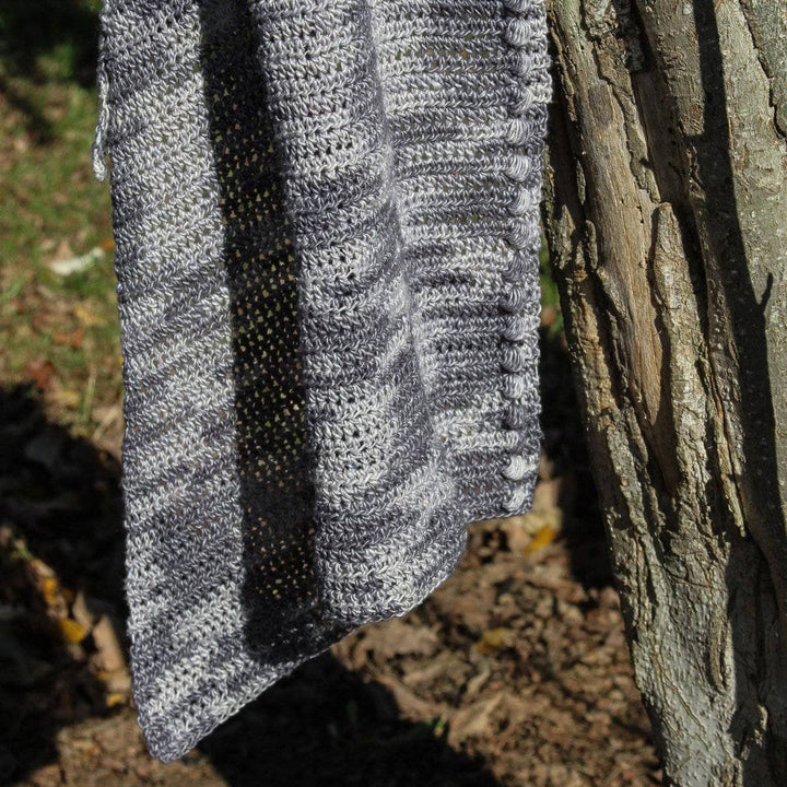 Andina Scarf in Date Night (grays) hanging from a tree