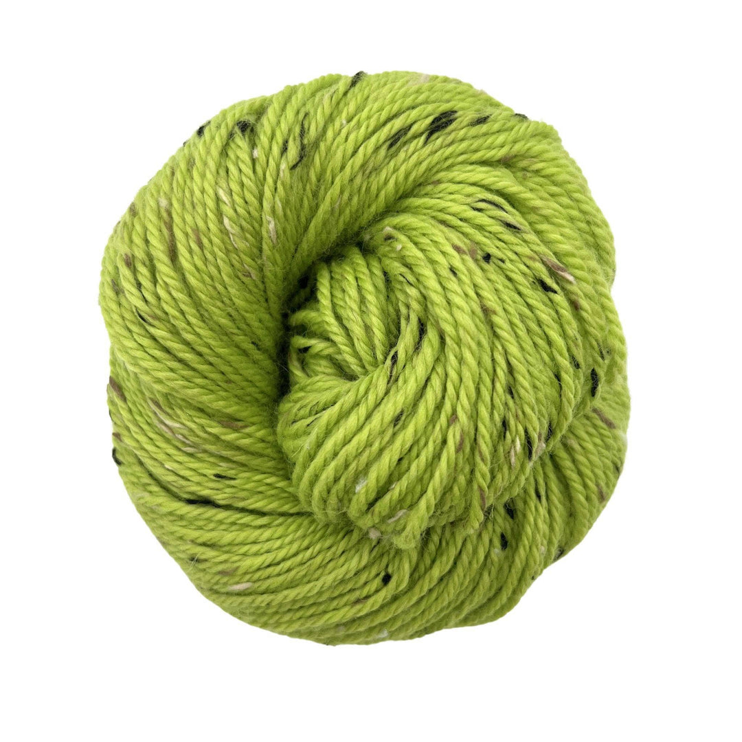 Light green yarn with small specks of brown on a white background. Aran Weight, Wool and Donegal nepps yarn.