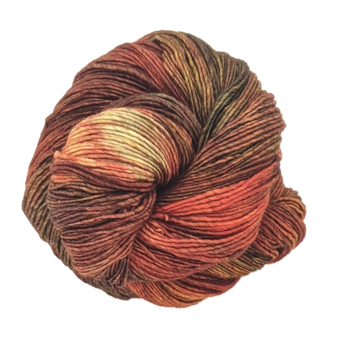 skein of tonal orange/brown yarn in front of a white background.
