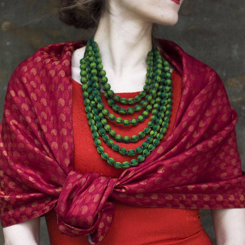 Woman wearing an Artisan Made Sari Silk & Cotton Scarf in red colors tied around her shoulders